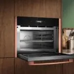 Встраиваемая компактная микроволновка Neff с конвекцией в кухне с медной отделкой